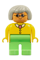 Female Duplo figure with medium green legs, wearing a yellow blouse with collar, gray hair, and glasses - 4555pb084