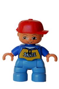 Duplo Child Boy - A boy Duplo figure from Lego Ville with medium blue legs, a blue top with 'SKATE' pattern, a red cap, and freckles - 47205pb011