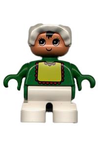 Duplo Baby - Child Duplo figure with white legs, wearing a green top with yellow bib and red lace, and a white bonnet - 6453pb024