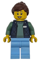 Female delivery worker with reddish brown hair, hearing aid, wearing a dark blue bodywarmer over a sand green sweater and bright light blue legs - cty1952