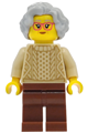 Grandmother with light bluish gray short wavy hair wearing a tan knit cable sweater and reddish brown legs - hol410